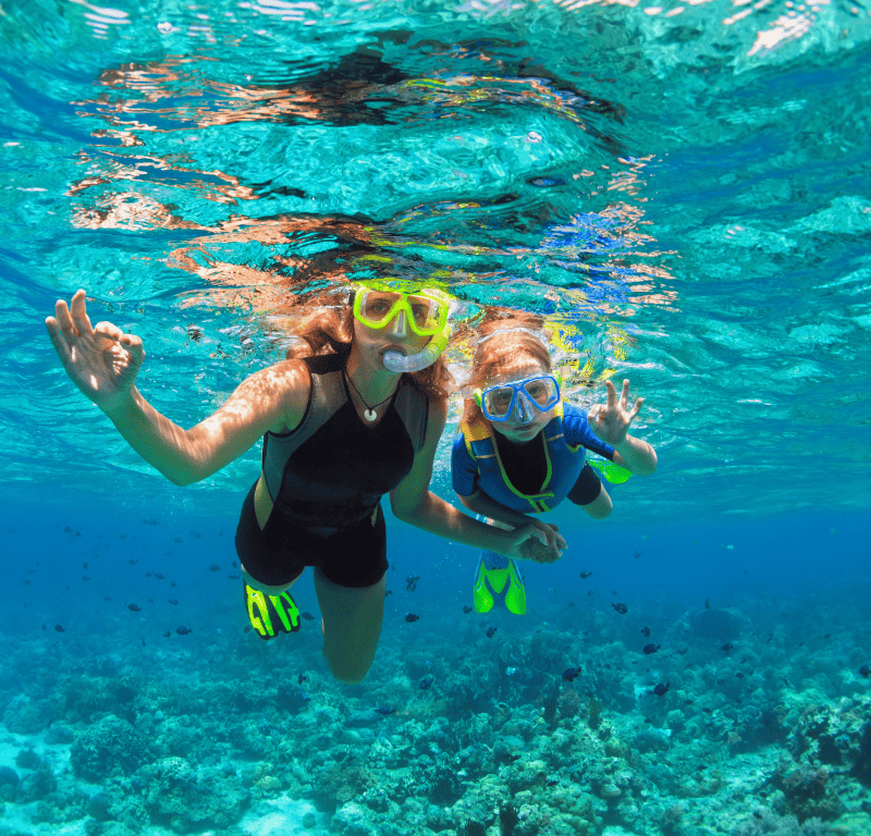 Families snorkeling off phuket andaman sea on a snorkeling tour with coral seekers