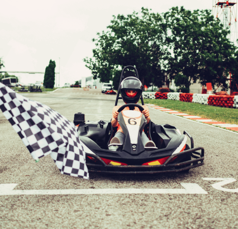 Iconic checkered flag waving triumphantly at the go-kart finish line, symbolizing the end of the race and the victorious conclusion of the thrilling competition.